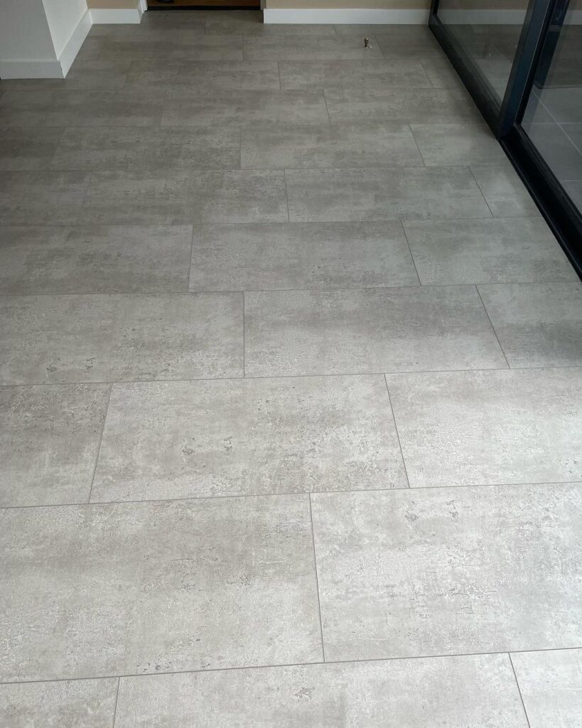 PVC vloer Asten: Betonlook PVC vloer in moderne woonkamer met stijlvolle inrichting.